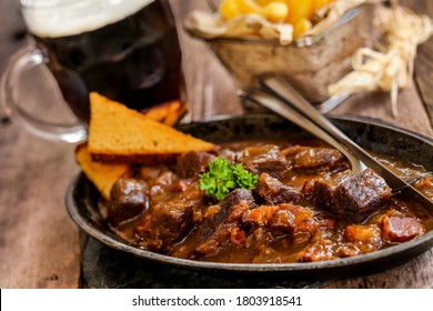 flemish stew with french fries, gingerbread and brown beer on wooden table