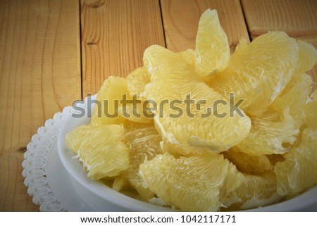 Flesh of fresh yellow pomelo on the wooden background