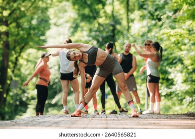Flexibility, warm up exercise. Group of runners are together outdoors.