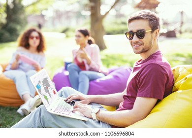 Flexible Hours. Nice Content Man Sitting In The Chair And Working On His Laptop