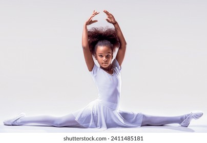 Flexible little african american girl ballerina. african girl ballet studio. Ballerina in dance class. Girl white tutu, leotard learning to dance. Child dancer exercising. Kids practice full split. - Powered by Shutterstock