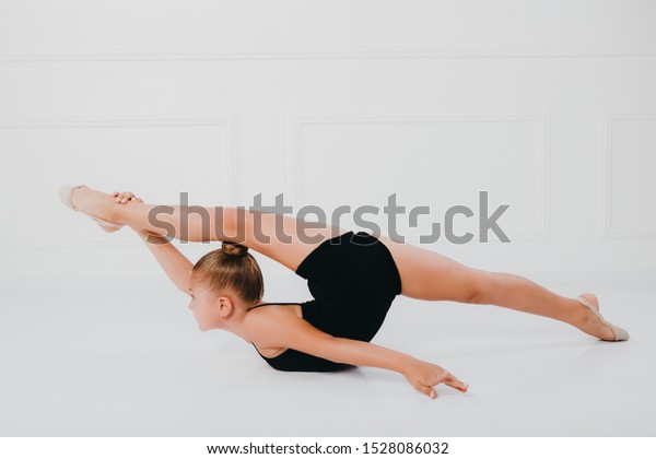 Little Girl Sits On A Splits Stock Photo - Download Image 