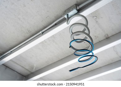 Flexible metal conduit (FMC) of ceiling electrical wiring in construction site background