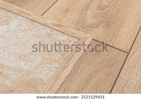 Flexible threshold for floor coverings. Joint of laminate and tile. Masking the seam of floor