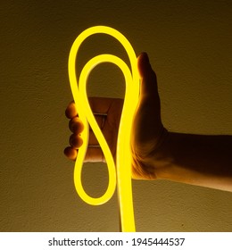 Flexible Yellow Led Tape Neon In Hand On Black Background.