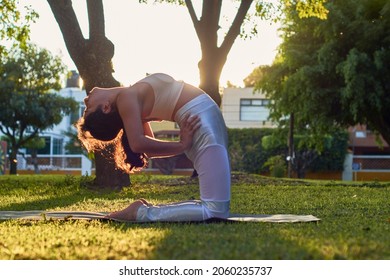 Flexible Young Latina Woman Practicing Yoga In The Park