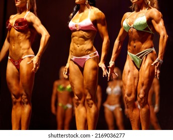 Flexing For The Judges. Female Body Building Contestants Flexing Their Muscles For The Judges.