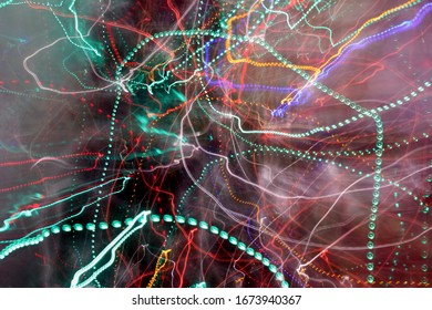 Flickering City Lights With A Slow Shutter Speed In Motion. Abstract Neon Lines, Zigzags, Dots, Circles. Movement In A Stopped Moment.