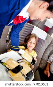 Flight Attendant Serving Food To A Kid In The Airplane