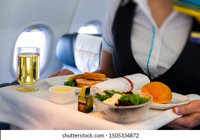 Flight Attendant Serving Meal In An Airplane 