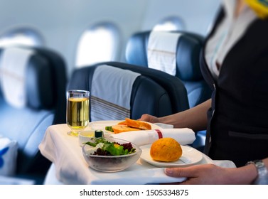 Flight Attendant Serving Meal In An Airplane 