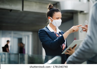 Flight Attendant Talking To Businessman On Airport, Wearing Face Mask.