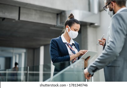 Flight attendant talking to businessman on airport, wearing face masks. - Powered by Shutterstock