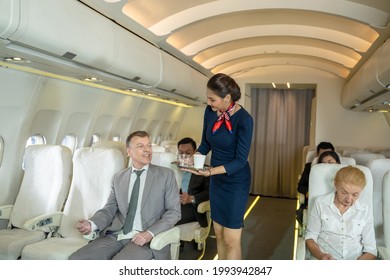 Flight Attendants Serve On Board,Air Hostess Serving Tea And Coffee In Airplane.