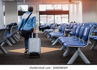 Flight Cancelled On COVID-19 Virus Disease Concept, Asian Traveler Senior Hold Luggage At Terminal Airport, Transit Flight Looking Info Board Feeling Alone After Flights Cancel Impact Covid19