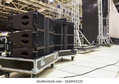Flight cases with line array speakers. Stage, trusses, led screen and sound speakers background. Installation of professional concert equipment. - Shutterstock ID 1624415122