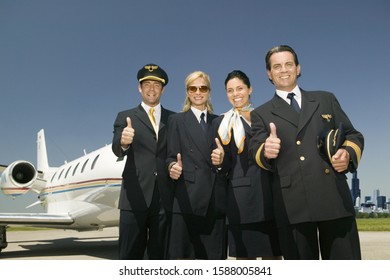 Flight Crew Giving Thumbs Up In Front Of Airplane On Tarmac