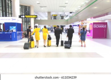 A Flight Crew Walking In The Airport. Blur Background.