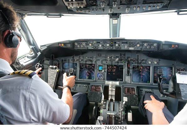 Flight Deck of small\
commercial aircraft.The pilots (cockpit crew) prepares for landing\
at the airport.