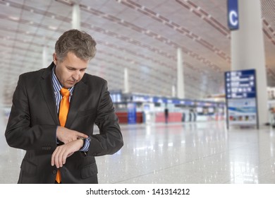 Flight delay. Businessman looking at his watch - Powered by Shutterstock