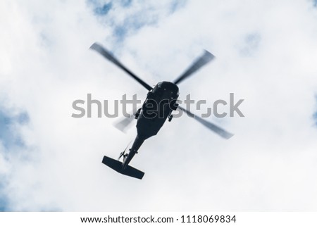 Flight of the helicopter,on sky background.