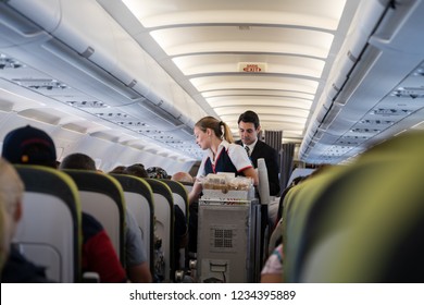 Flight Lisbon-Funchal, August 26, 2018: Stewardess And Steward Carry Food And Drinks In The Cabin.