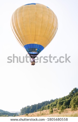 Flight on hot air balloon. Bottom view of colorful yellow hot air balloon flying in beautiful field at summer sunset