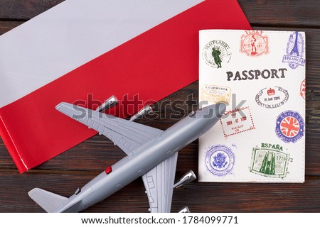 Flight to Poland concept. Toy passanger airplane with passport and flag of Poland flat lay top view.