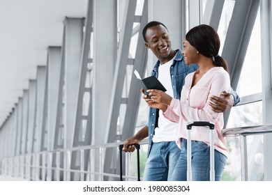 Flight Resumption. Portrait Of Cheerful Young Black Spouses Standing In Airport Terminal, Happy African American Couple Holding Passports And Tickets, Waiting For Plane Boarding, Free Space