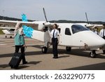Flight school students and pilot posing with small airplane
