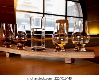 Flight Of Single Malt Scotch Whisky In Glasses Served In Bar In Edinburgh, UK, Tasting Of Dram Of Whiskey