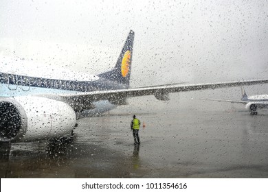 Flight Stranded During Rain And Bad Weather In Mumbai Airport, India. Airport Staff Standing Looking At The Clouds.