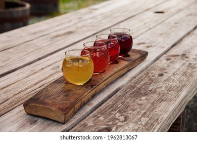 Flight Of Sustainably Produced Craft Ciders Served On A Reused Barrel Stave. Colorful, Natural, Drinks 