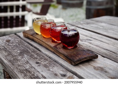 Flight Of Sustainably Produced Craft Ciders Served On A Reused Barrel Stave. Colorful, Natural, Drinks 