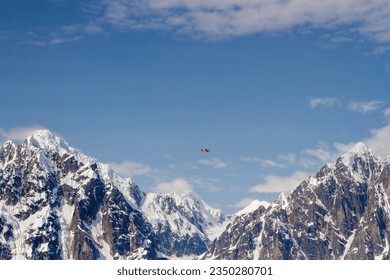 Flightseeing float plane against blue skies over Denali National Park mountains.