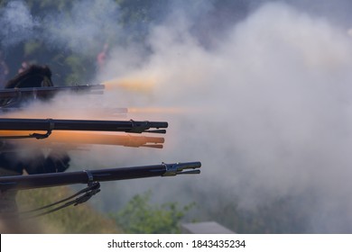 Flintlock Muzzle Loader Muskets Guns Firing. Smoke From The Gunpowder Fills The Air.