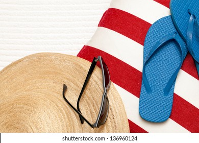 Flip Flops, Hat, Towel, And Sunglasses For A Day At The Beach, Pool Or Spa. Red White And Blue Color Theme.  Copy Space. Top View, Looking Down.