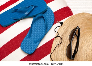 Flip Flops, Hat, Towel, Sunglasses And Earphones For A Day At The Beach, Spa Or Pool. Red, White And Blue Theme. Horizontal Format. Top View, Looking Down.