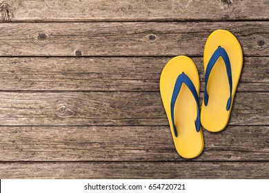 Flip flops isolated on wooden floor. Top view and copy space. Slippers yellow - Powered by Shutterstock