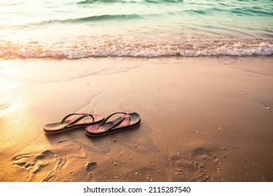 Flip flops or sandals for woman on sand beach at coast with effect light sun set on sea. tourism relax travel tropical summer in holidays or broken heart concept. free space image.