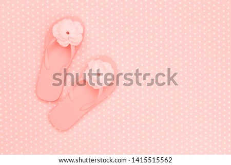 flip flops shoes with flower in living coral color, top view, with copy space.  Coral Toe sandals on polka dot background, flat lay, text place. 