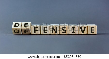 Fliped wooden cubes and changed the inscription 'offensive' to 'defensive' or vice versa. Beautiful grey background, copy space.