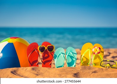 Papucsok, strandlabda és légzőcső a homokon. Nyári vakáció koncepció