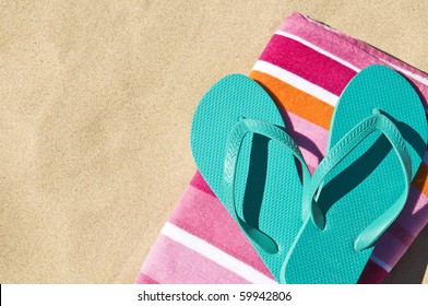 Flip-flops/Thongs And Towel On White Sand.