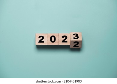 Flipping of 2022 to 2023 on wooden block cube for preparation new year change and start new business target strategy concept. - Shutterstock ID 2104451903