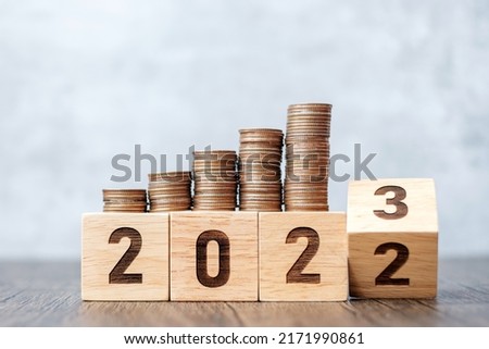 flipping 2022 to 2023 year block with Coins stack. Money, Budget, tax, investment, financial, savings and New Year Resolution concepts
