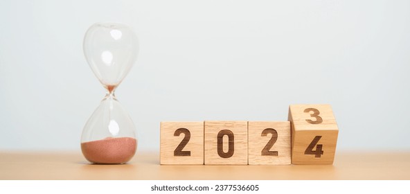 flipping block 2023 to 2024 text with hourglass on table. Resolution, time, plan, goal, motivation, reboot, countdown  and New Year holiday concepts