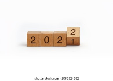 flipping cubes with year 2021 to 2022. new year concept. copy space. 3D wooden cube flip over wooden block isolated in white background