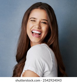 Flirt, portrait and wink with funny woman in studio on gray background for emotion or expression. Cute, face and playful with happy model laughing at comedy, humor or joke for emoji reaction - Powered by Shutterstock