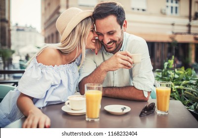 Flirting in a cafe. Beautiful loving couple sitting in a cafe drinking coffee and enjoying in conversation. Love, romance, dating